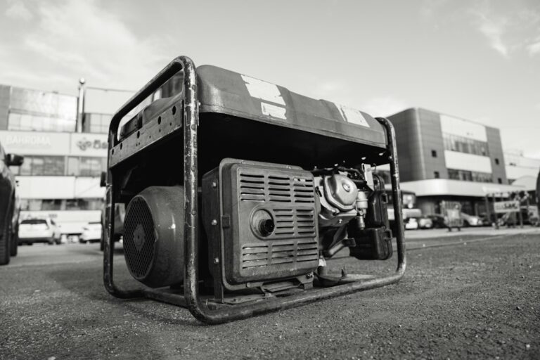 Homeowner checking appliance wattage labels beside a portable generator and a handwritten load worksheet.